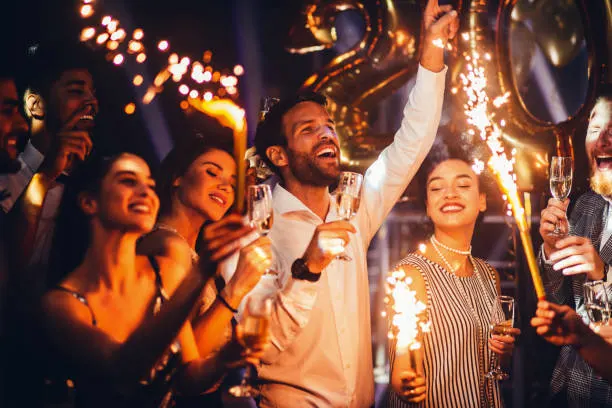 Party guests dancing with sparklers
